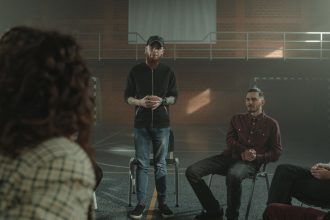 Grupo diverso de pessoas sentadas em círculo durante uma sessão de apoio em saúde mental.