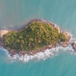 Vista aérea de uma ilha verde cercada pelo mar azul-turquesa em Ubatuba, no Litoral Norte de São Paulo