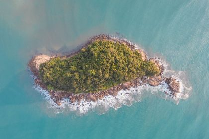 Vista aérea de uma ilha verde cercada pelo mar azul-turquesa em Ubatuba, no Litoral Norte de São Paulo